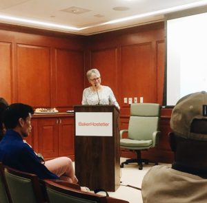 Martha Knisley stands at the front of the conference room at a podium to discuss and reflect on the 20 years since the Olmstead decision took place.