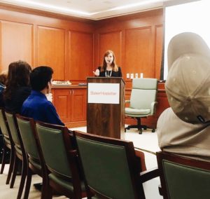 Eve Hill stands at the front of the conference room at a podium to discuss and reflect on the 20 years since the Olmstead decision took place.